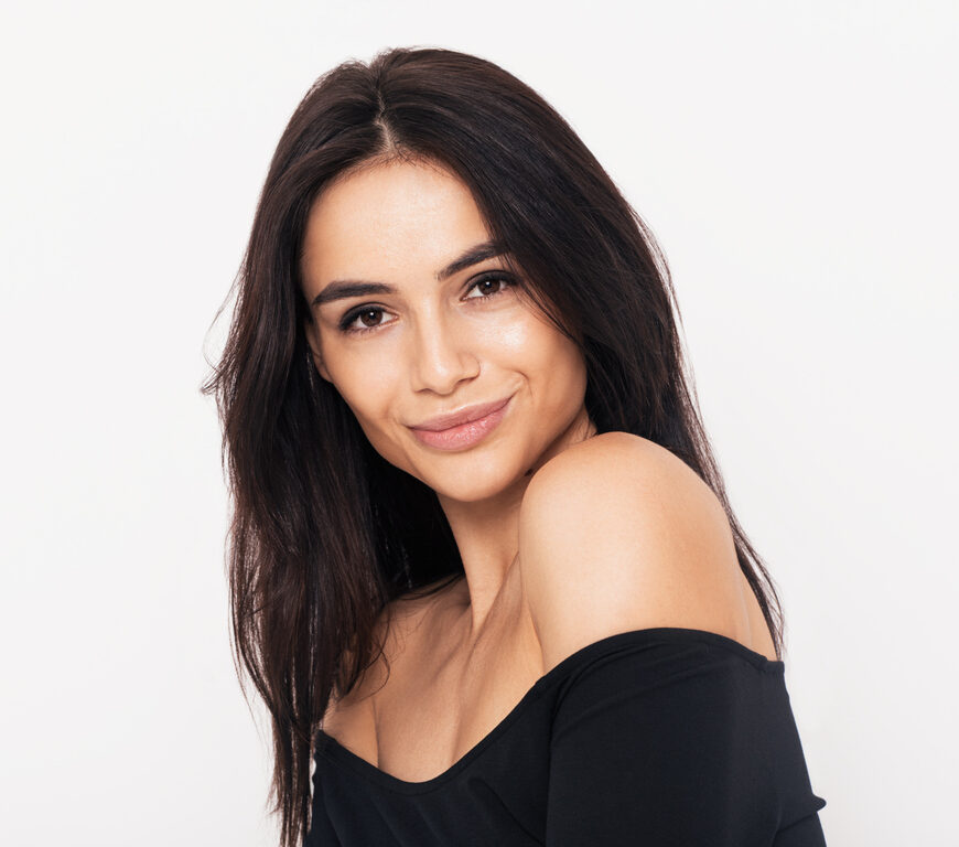 Close up portrait of an attractive woman in black dress with open shoulders